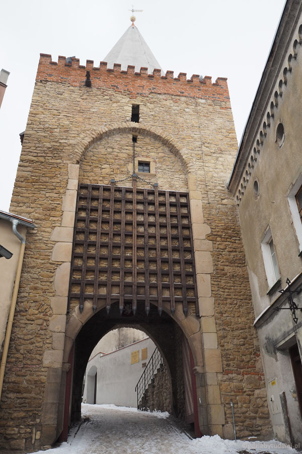 Brama została wzmocniona żelazną kratą i wieżą z krenelażem.